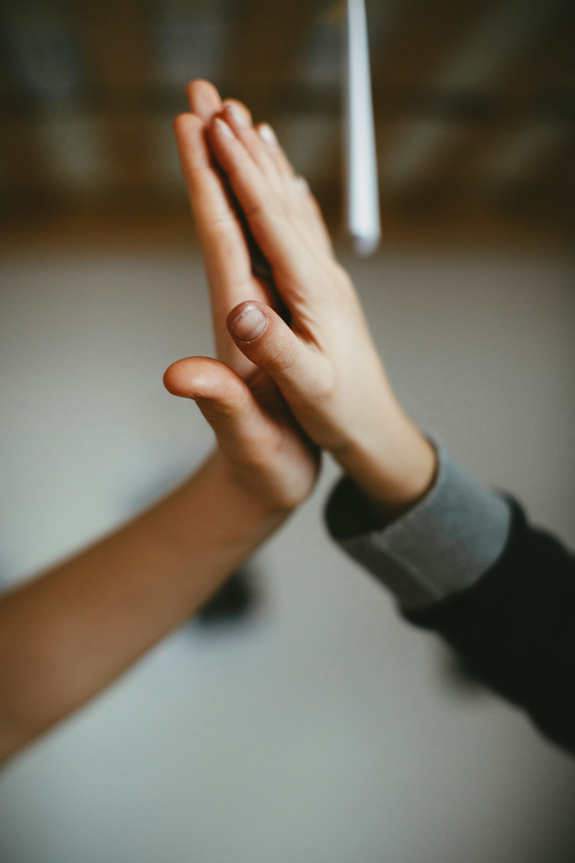 A child's hand and an adult's hand meeting palm to palm